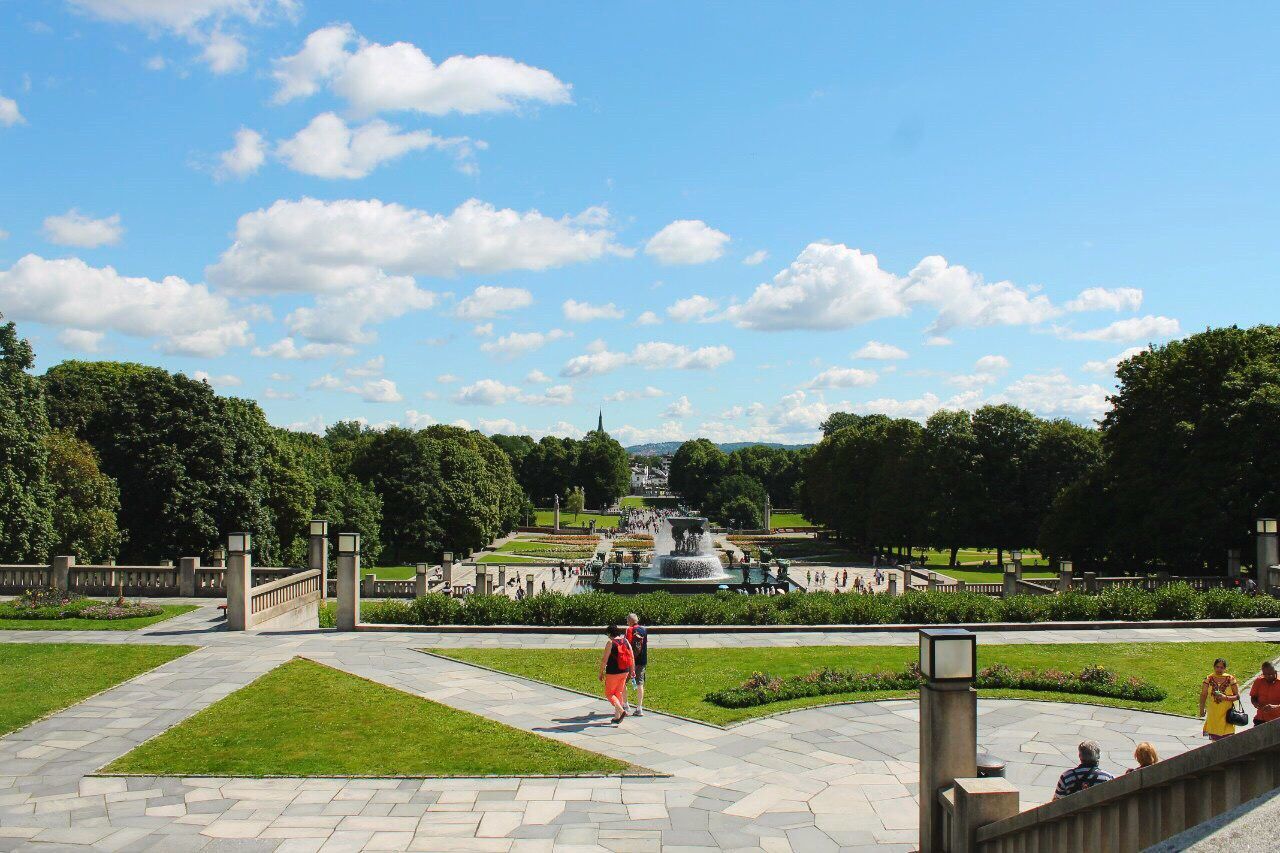 tree, sky, grass, lifestyles, person, leisure activity, park - man made space, cloud - sky, men, built structure, architecture, bench, cloud, building exterior, large group of people, green color, sitting, railing, sunlight