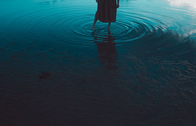 Low section of silhouette woman standing at beach