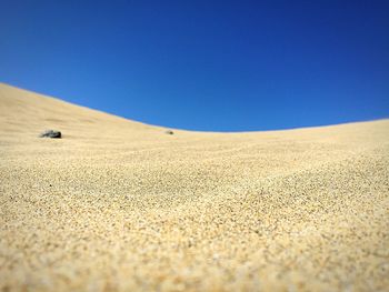 View of maspalomas dunes against clear blue sky on sunny day