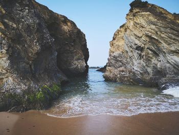 Rock formations in sea against sky