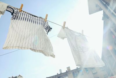 Low angle view of clothesline against sky on sunny day