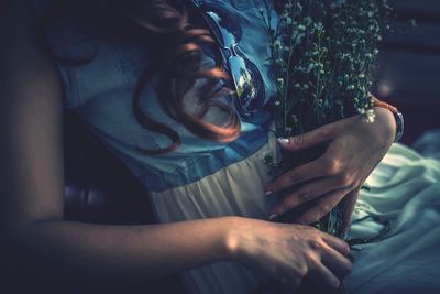 Midsection of woman holding plants outdoors