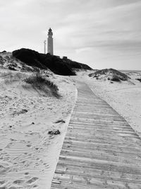 Scenic view of beach and lighthouse against sky