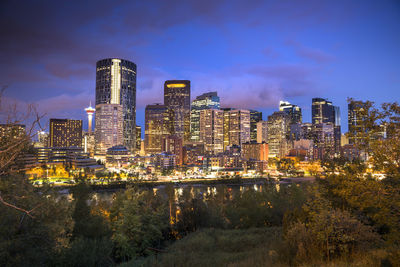 Illuminated cityscape against sky at night