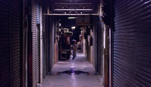 Ghost in corridor amidst closed shop at night