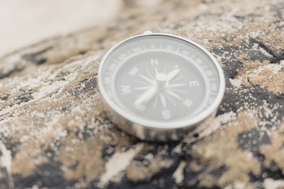 Close-up of navigational compass on rock