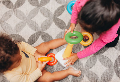 Directly above shot of cute girl playing with toy sitting on floor