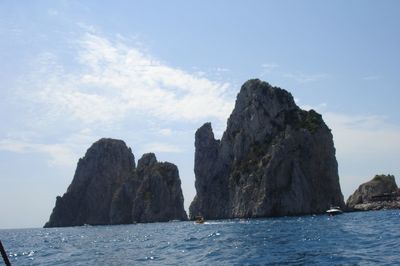Scenic view of sea by mountains against sky