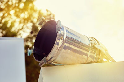 Close-up of beer glass bottle against sky