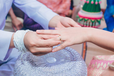 Midsection of couple holding hands