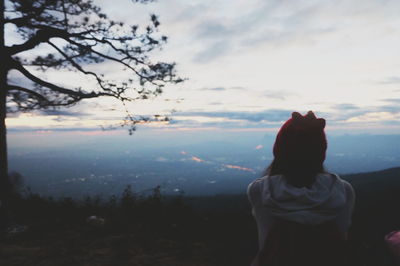 Rear view of woman standing on landscape against sky