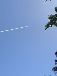 Low angle view of vapor trail against clear blue sky