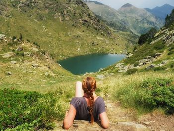 Rear view of man sitting on mountain