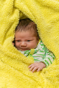 Infant baby wrapped in yellow blanket