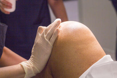 Midsection of doctor giving treatment to patient at hospital