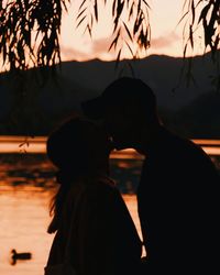 Silhouette couple against sky during sunset