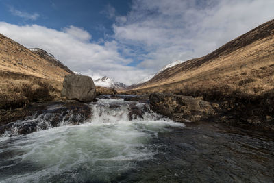 Scenic view of waterfall against sky