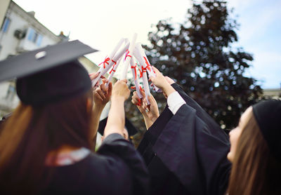 Group of university graduates in student robes or mantle and square hats 