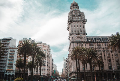 Low angle view of buildings against cloudy sky