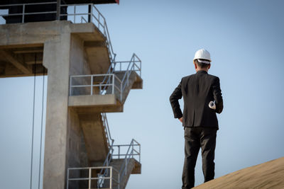 Low angle view of man working against sky