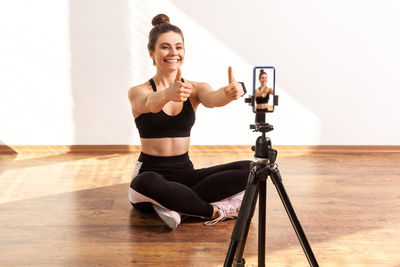 Full length of young woman exercising in gym