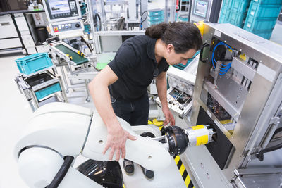 Man with assembly robot in factory