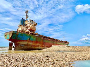 Traditional windmill on beach against sky