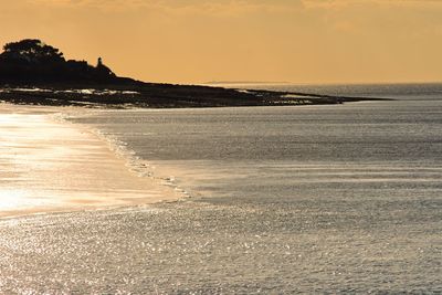 Scenic view of beach against sky during sunset
