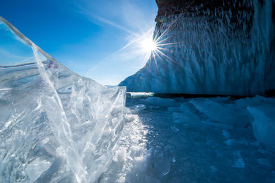 Scenic view of frozen lake against bright sun