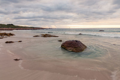 Rocks on beach against sky