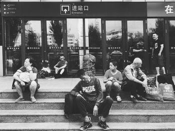 People sitting on street in city