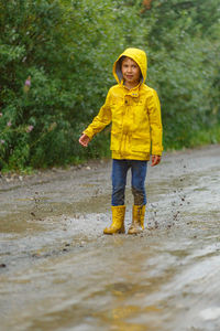 Full length of a boy standing in rain