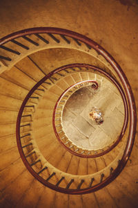 High angle view of woman standing below spiral staircase