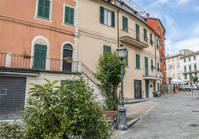 Residential building by street against sky