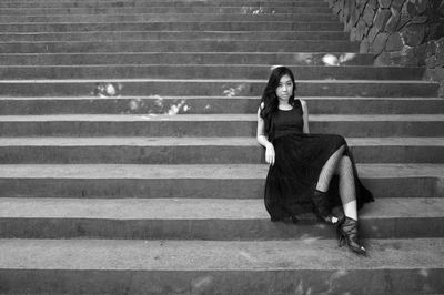 Full length portrait of beautiful woman reclining on stairs