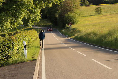 Rear view of man riding motorcycle on road