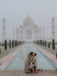 Rear view of woman standing against built structures