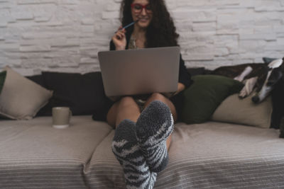 Low section of woman using laptop at home