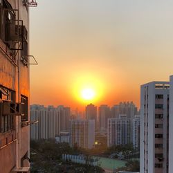 Buildings in city against sky during sunset