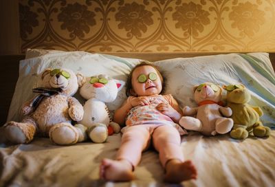 Full length of cute baby sleeping on bed at home