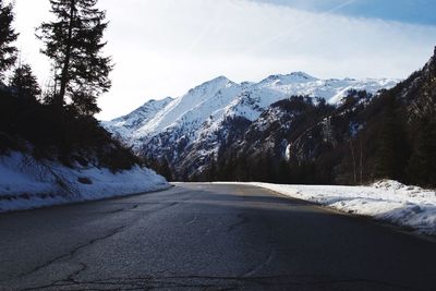 Road amidst snowcapped mountains against sky