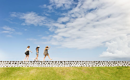 Three women walking on wall