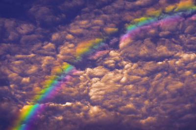 Low angle view of rainbow against cloudy sky