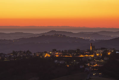 High angle view of illuminated city at sunset