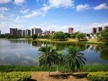 Scenic view of lake by city against sky