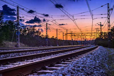 Railroad tracks against sky during sunset