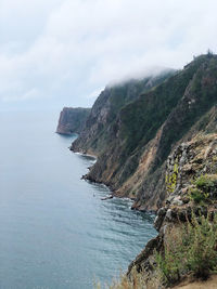 Scenic view of sea and mountains against sky