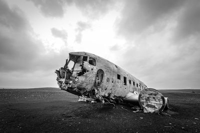 Abandoned airplane on runway against sky