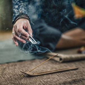 Close-up of hand holding incense stick