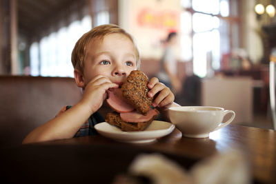 Close-up of boy eating breakfast at cafe